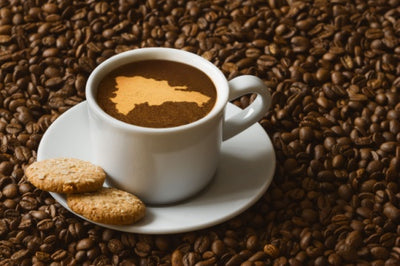 Cup of Cafe Santo Domingo 100% Puro Cafe hot coffee beverage with map of Dominican Republic, cookies and coffee beans